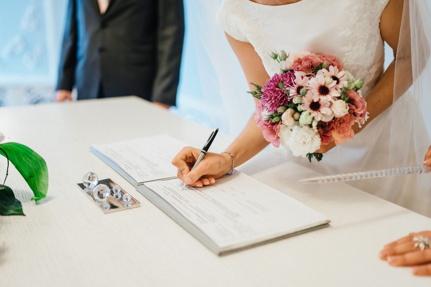 Bride signing a wedding venue contract on the day of the event