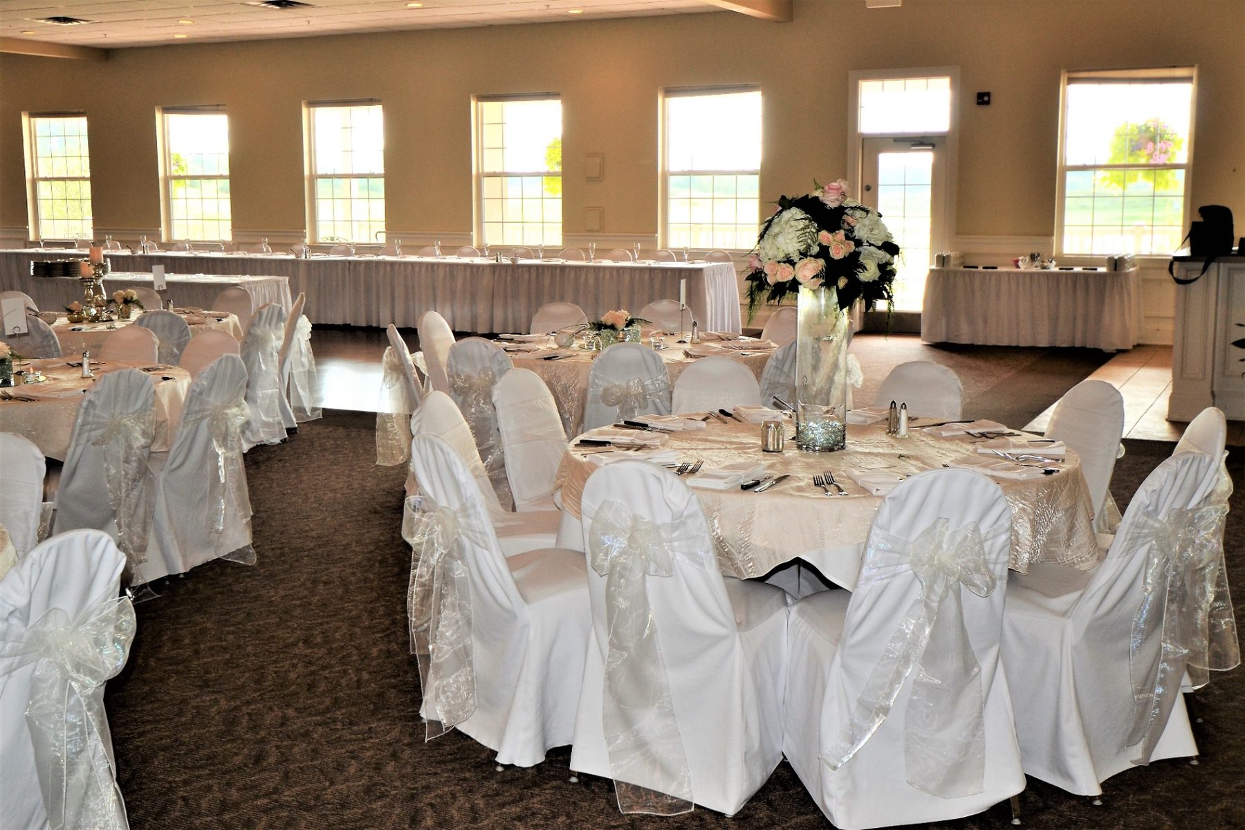 Banquet hall wedding reception with white chair covers and round tables